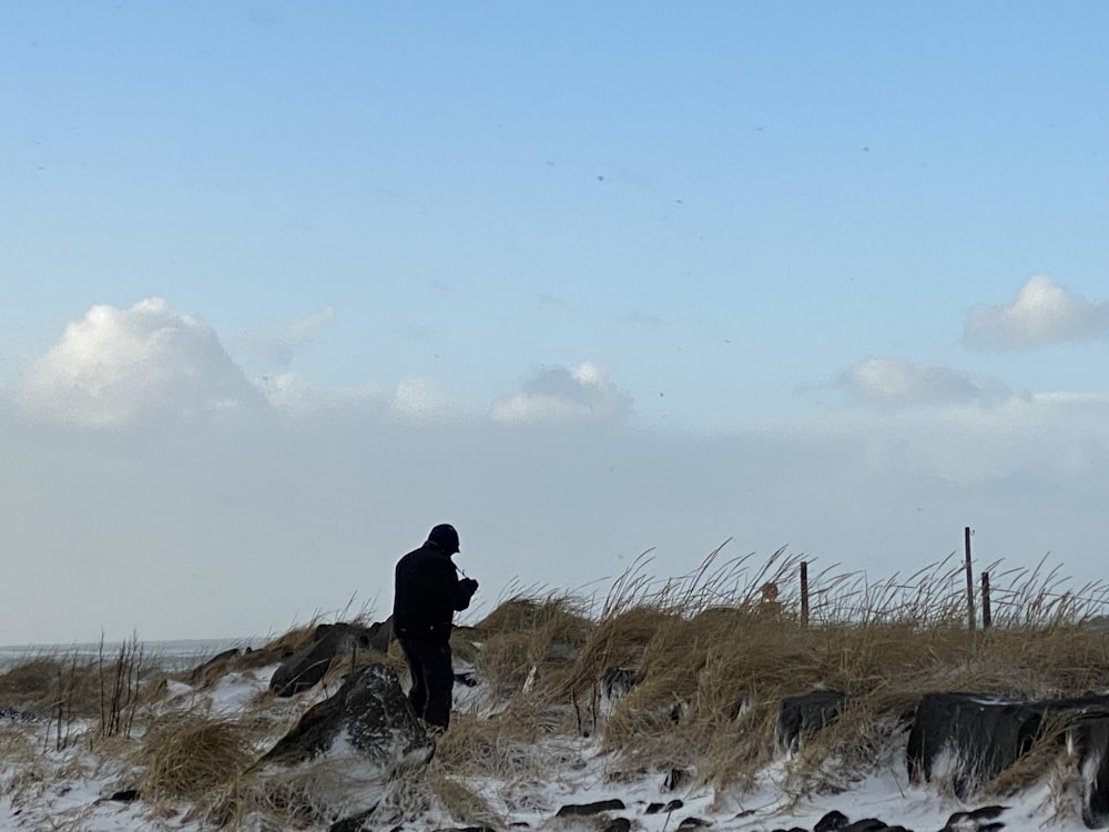 a person standing in a field with a kite