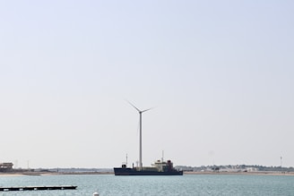 Engineers working on a wind turbine prototype near the ocean