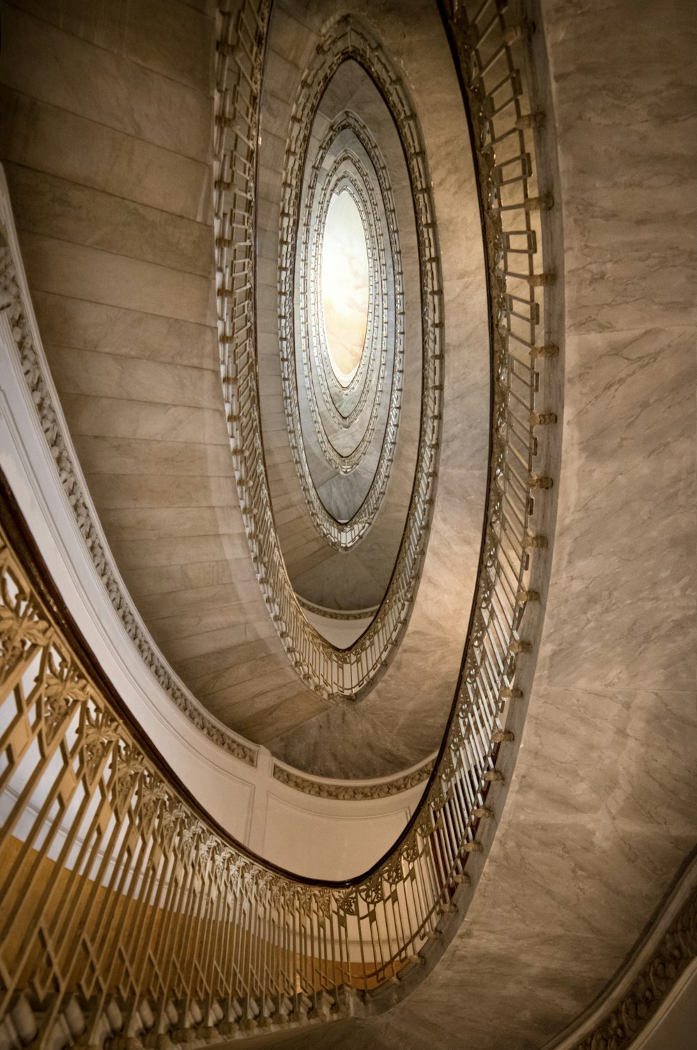 a spiral staircase in a building with a circular window