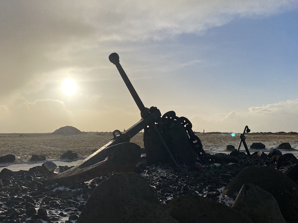 a large metal object sitting on top of a rocky beach