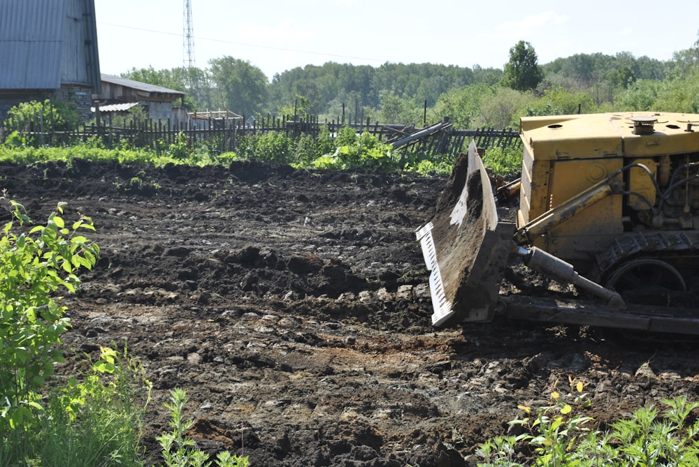 a bulldozer digging through a field of dirt