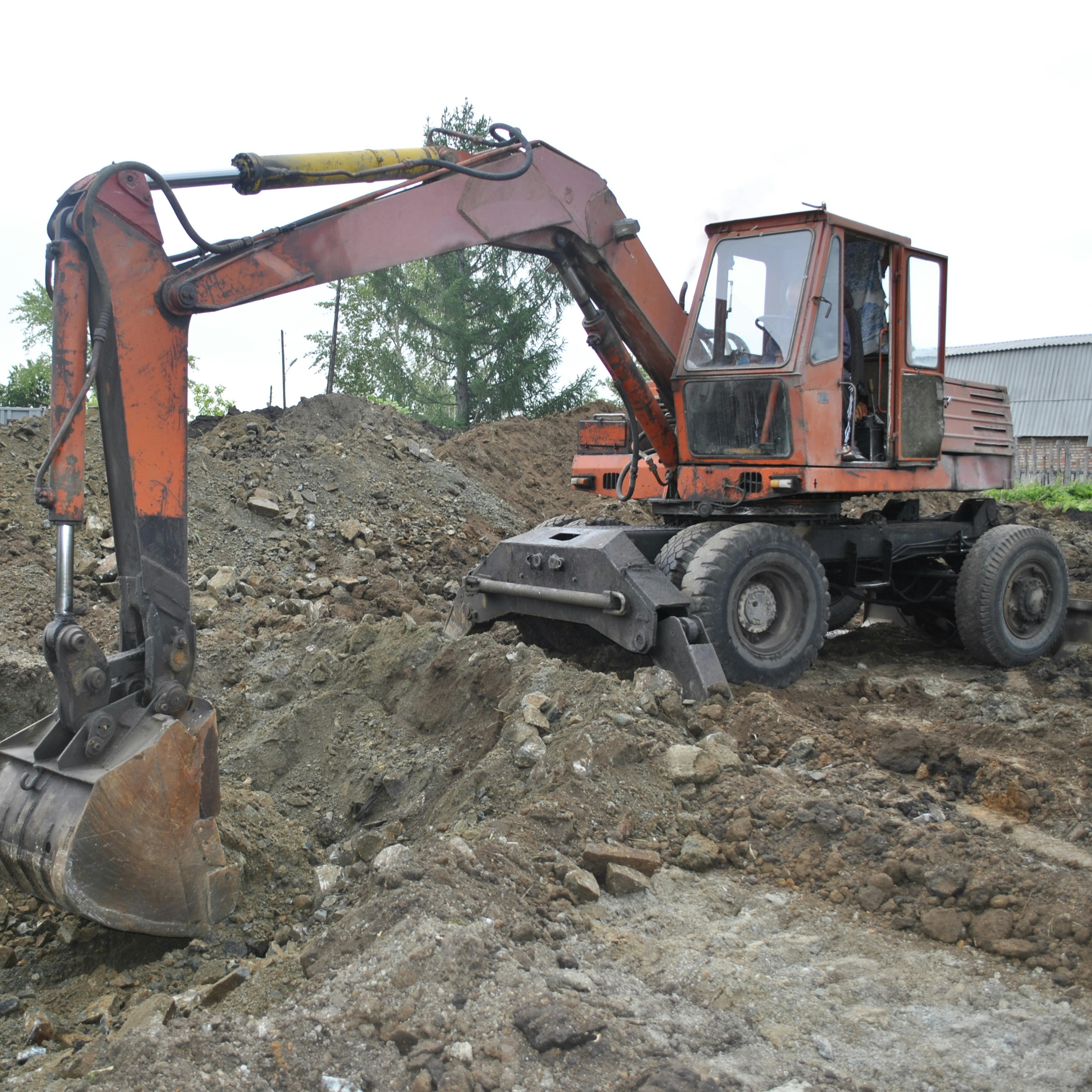 an orange and black bulldozer digging a pile of dirt