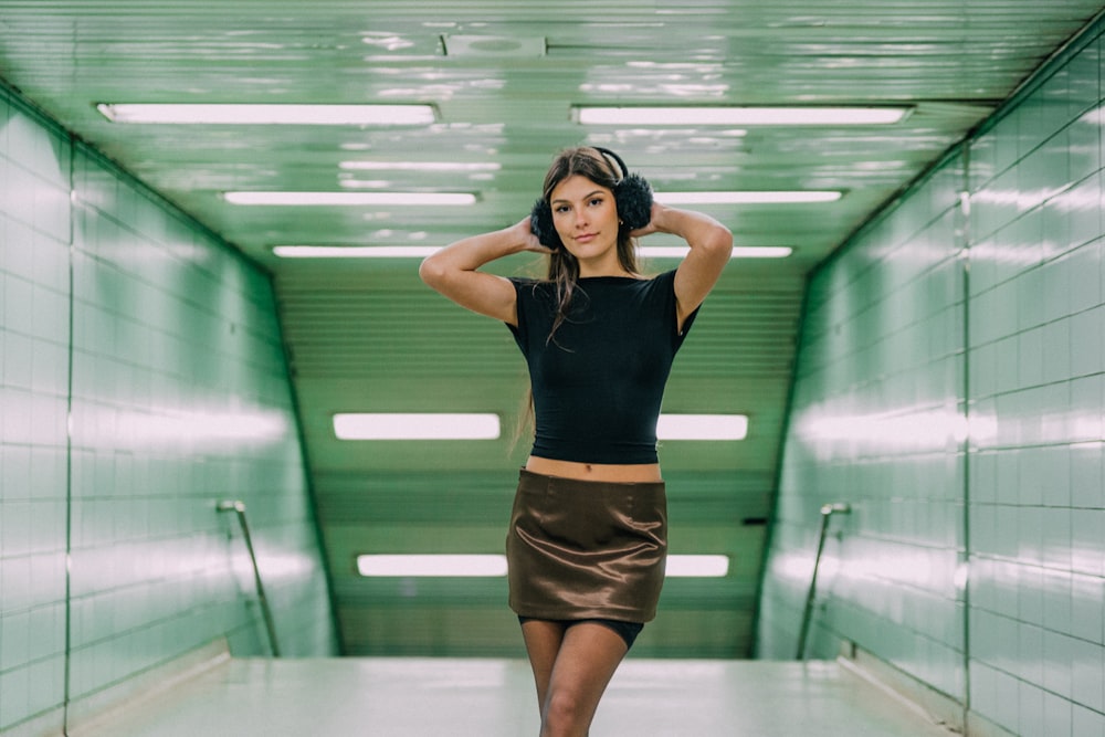 a woman in a black top and a brown skirt