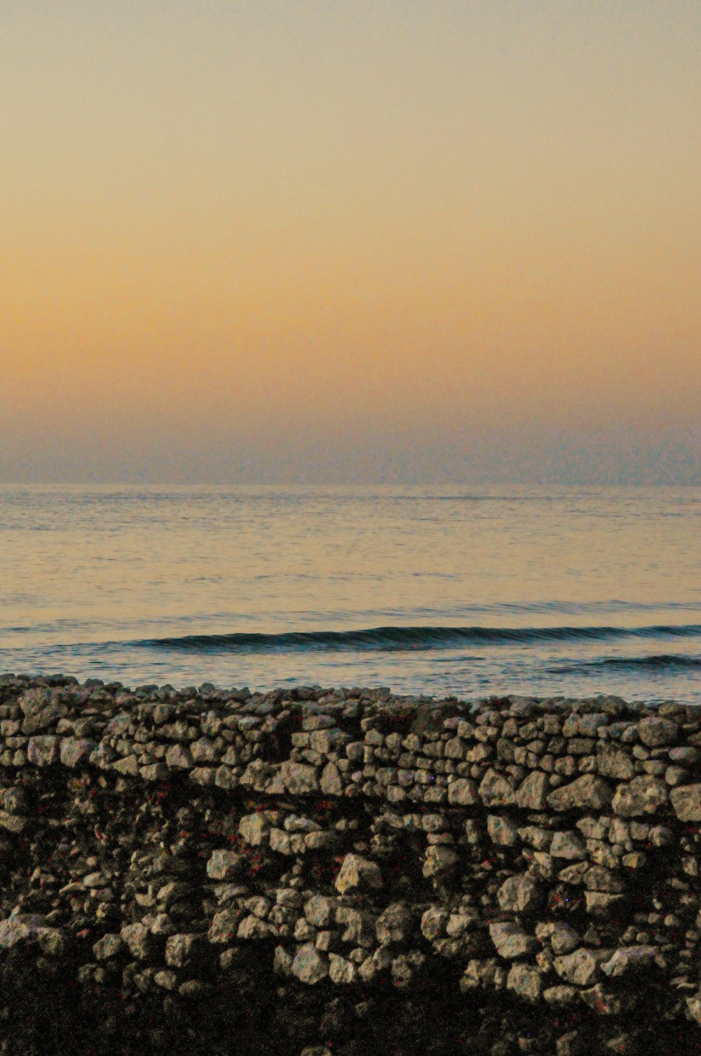 a person standing on a beach with a surfboard