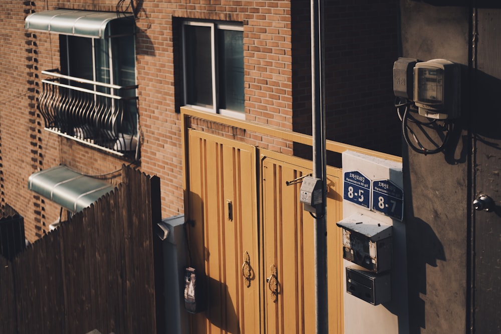 a brick building with a wooden door next to a parking meter