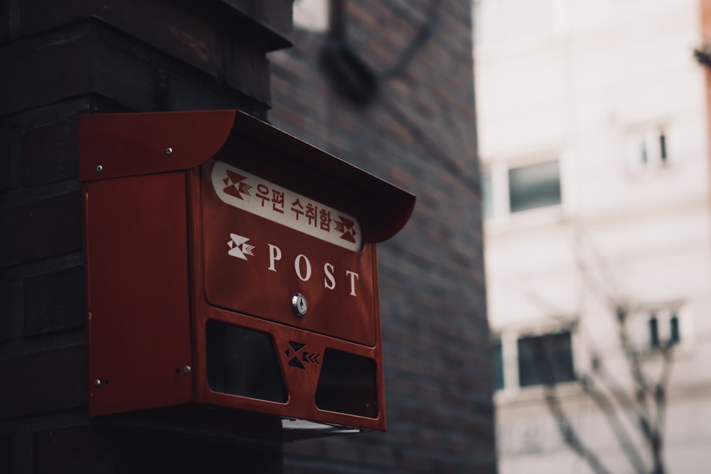 a red post box on the side of a building