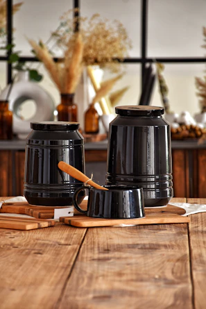 A rustic wooden table displaying keratribe’s heritage pickles and podi series jars.
