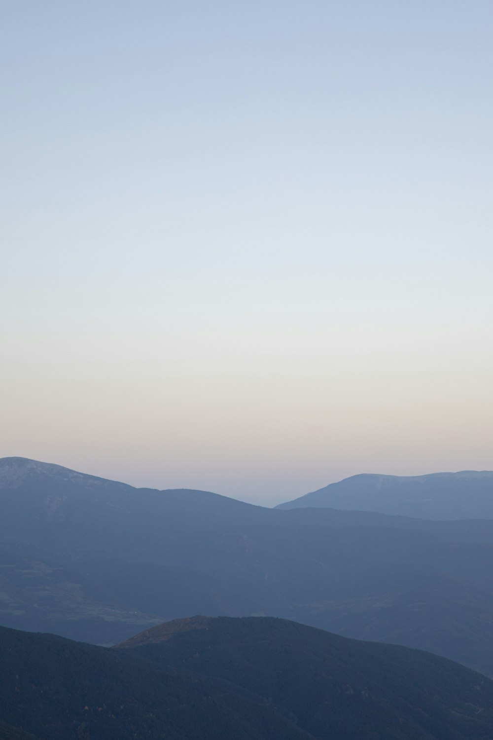 a plane flying over a mountain range at dusk