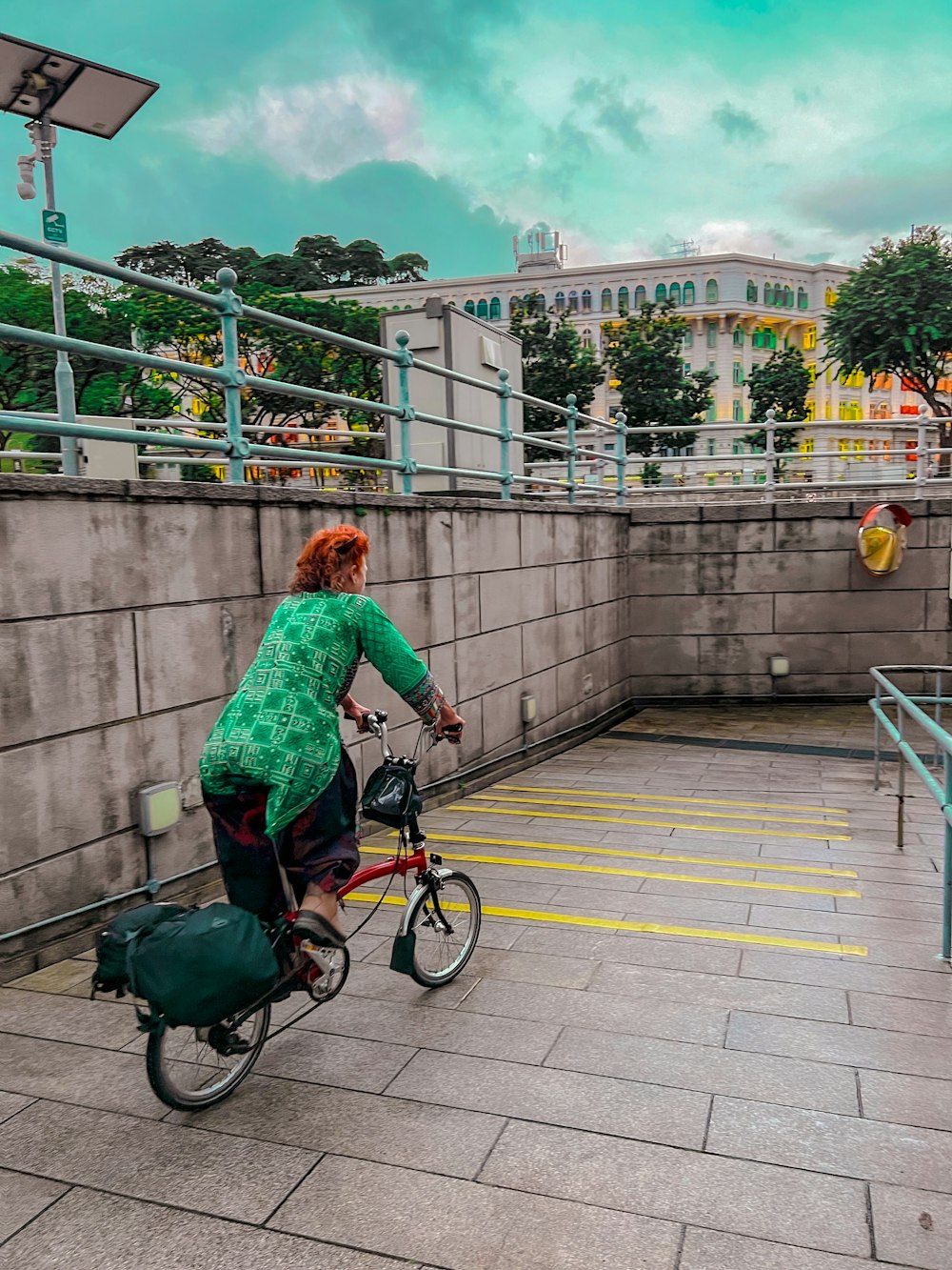 a woman riding a bike down a walkway