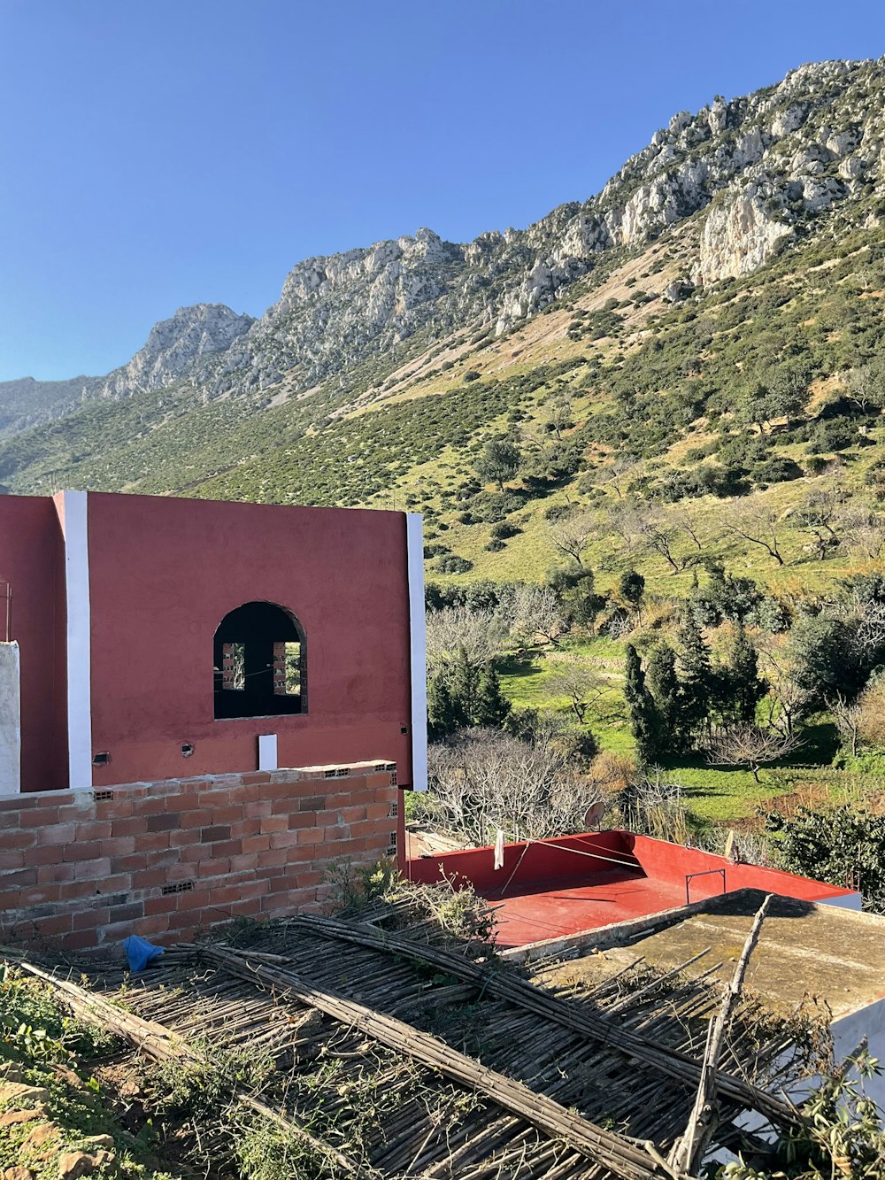 a red building with a window in the middle of a mountain