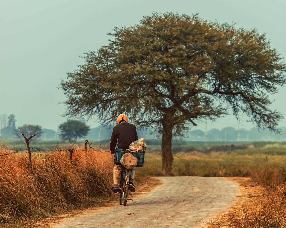 a man riding a bike down a dirt road