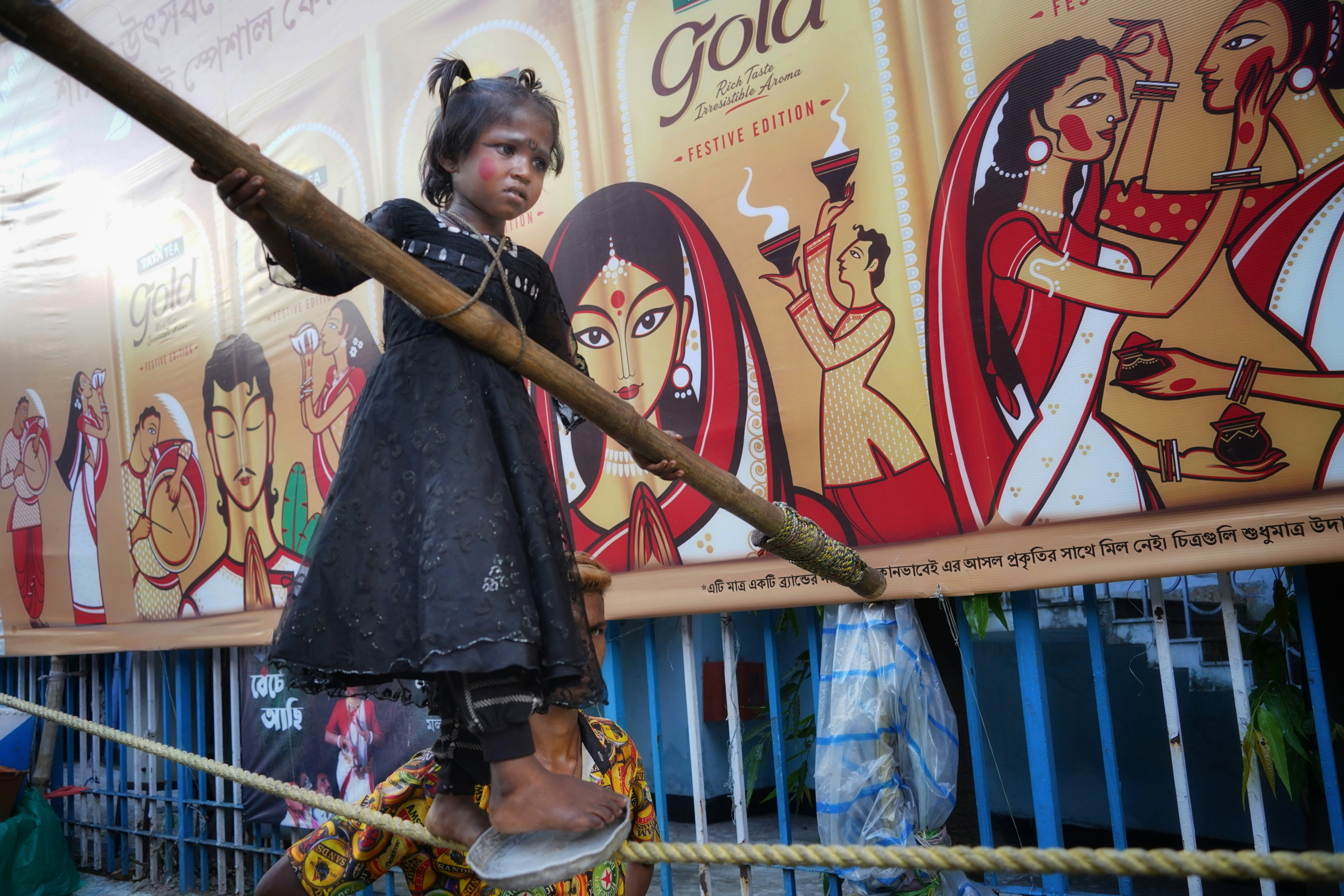 a young girl standing on top of a wooden pole