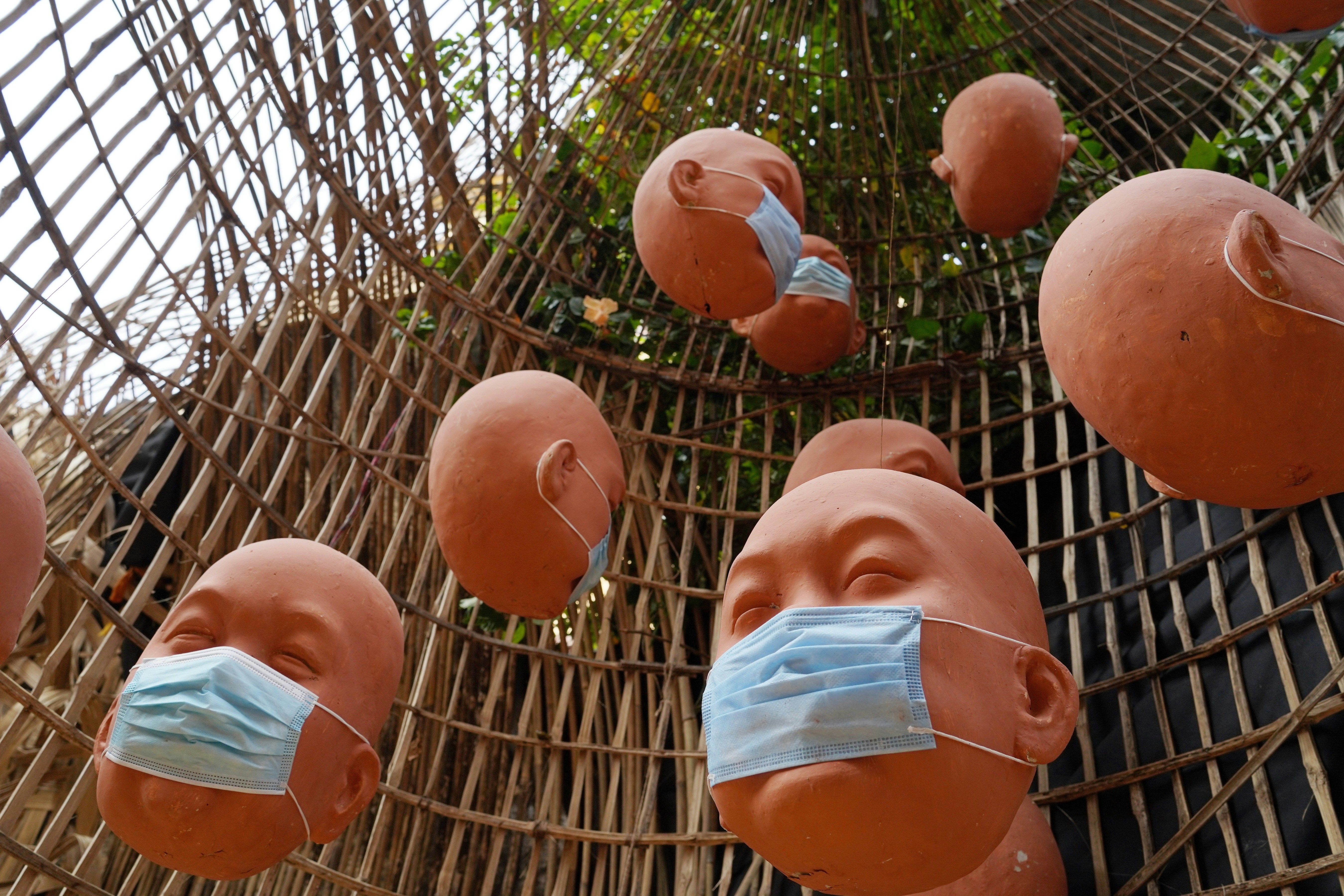 a group of clay heads with surgical masks on