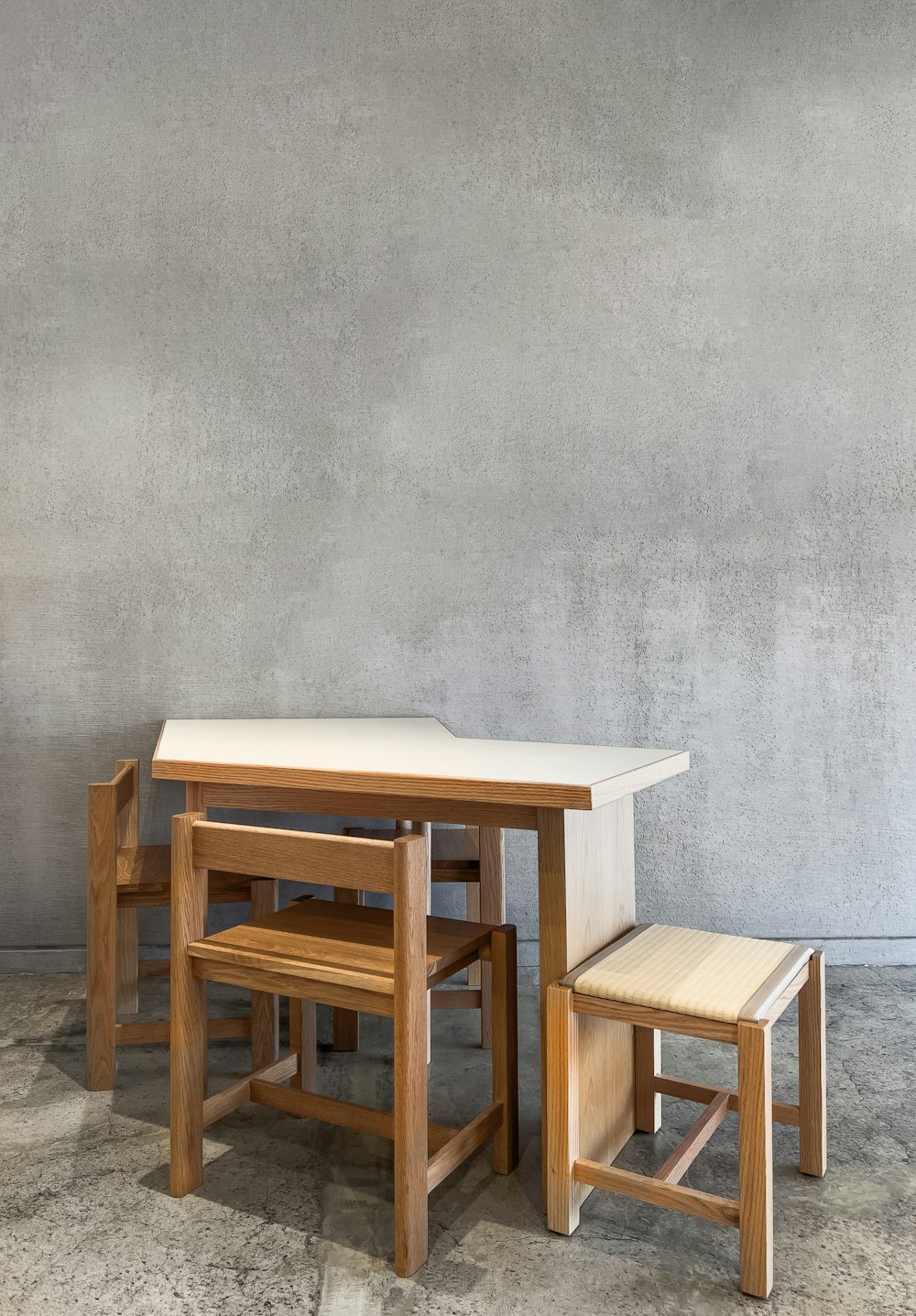 a table and two stools against a wall