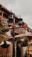 Elegant outdoor seating area with vintage lanterns and blooming flowers in a Normandy-style home.