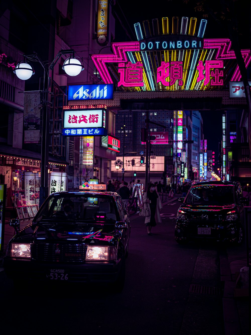 a busy city street at night with neon signs