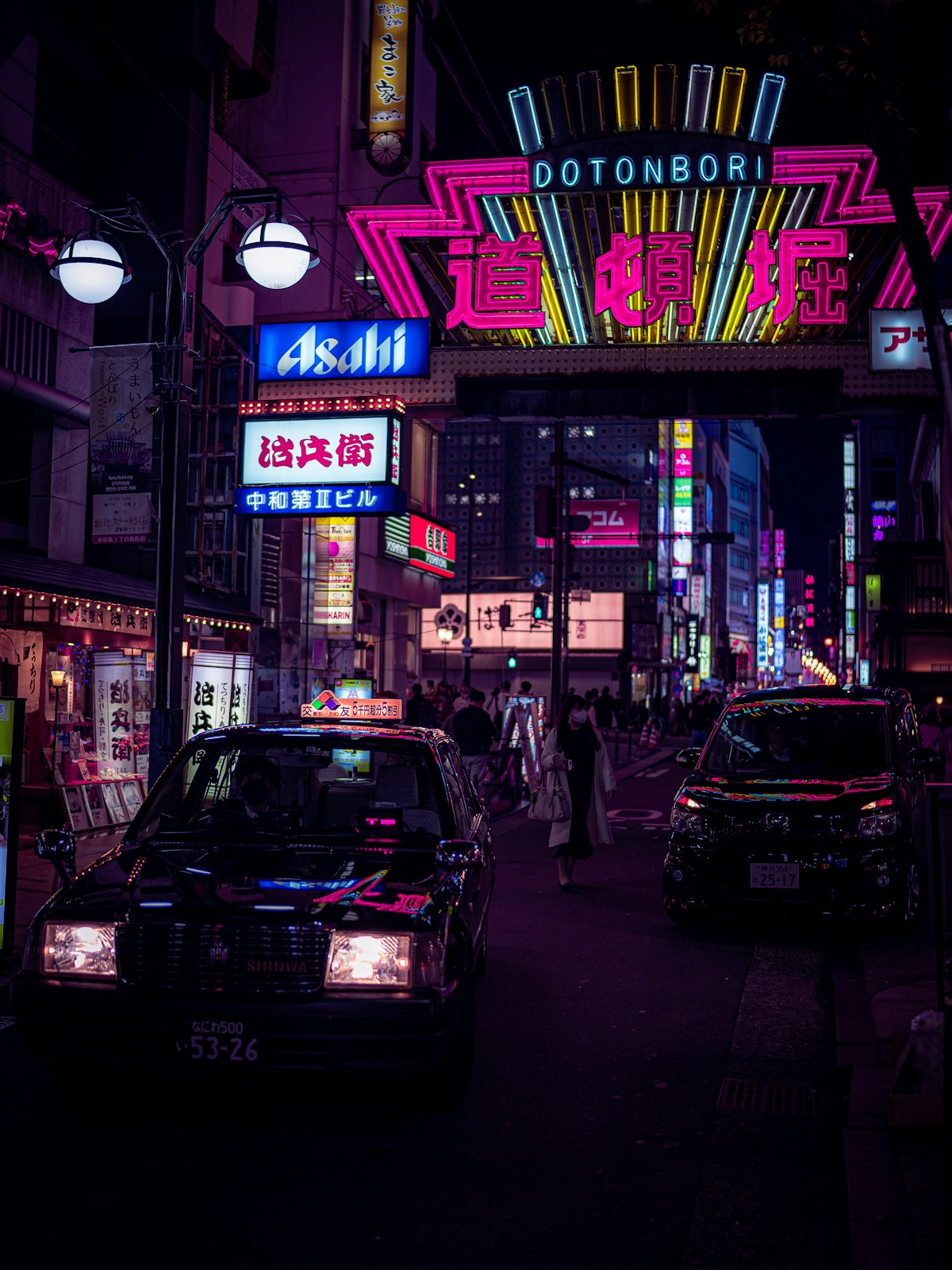 A busy Osaka city street at night with neon signs