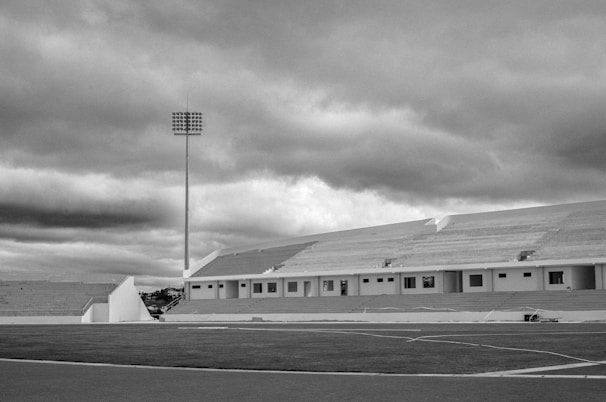 Wide shot of the stadium before renovation, showing worn-out stands and empty field under grey skies