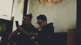 A warm, inviting illustration of two people chatting anonymously through their phones, surrounded by soft, calming colors.