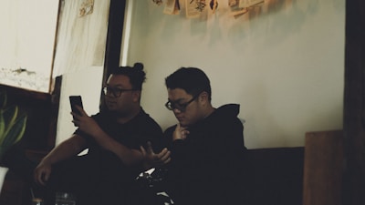 A cozy, dimly lit room with two people chatting intimately on their phones.