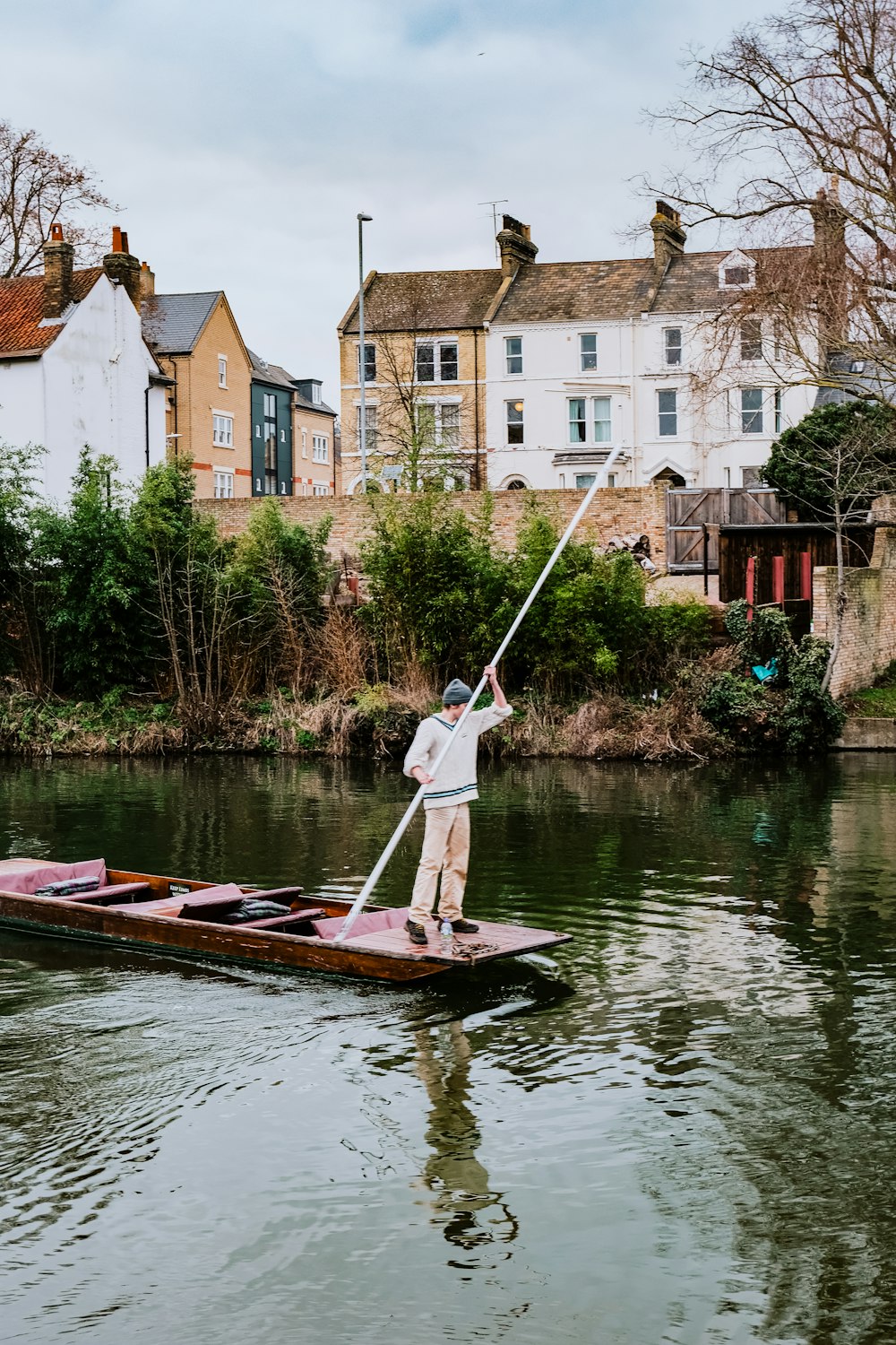 a man standing on a paddle boat in a river
