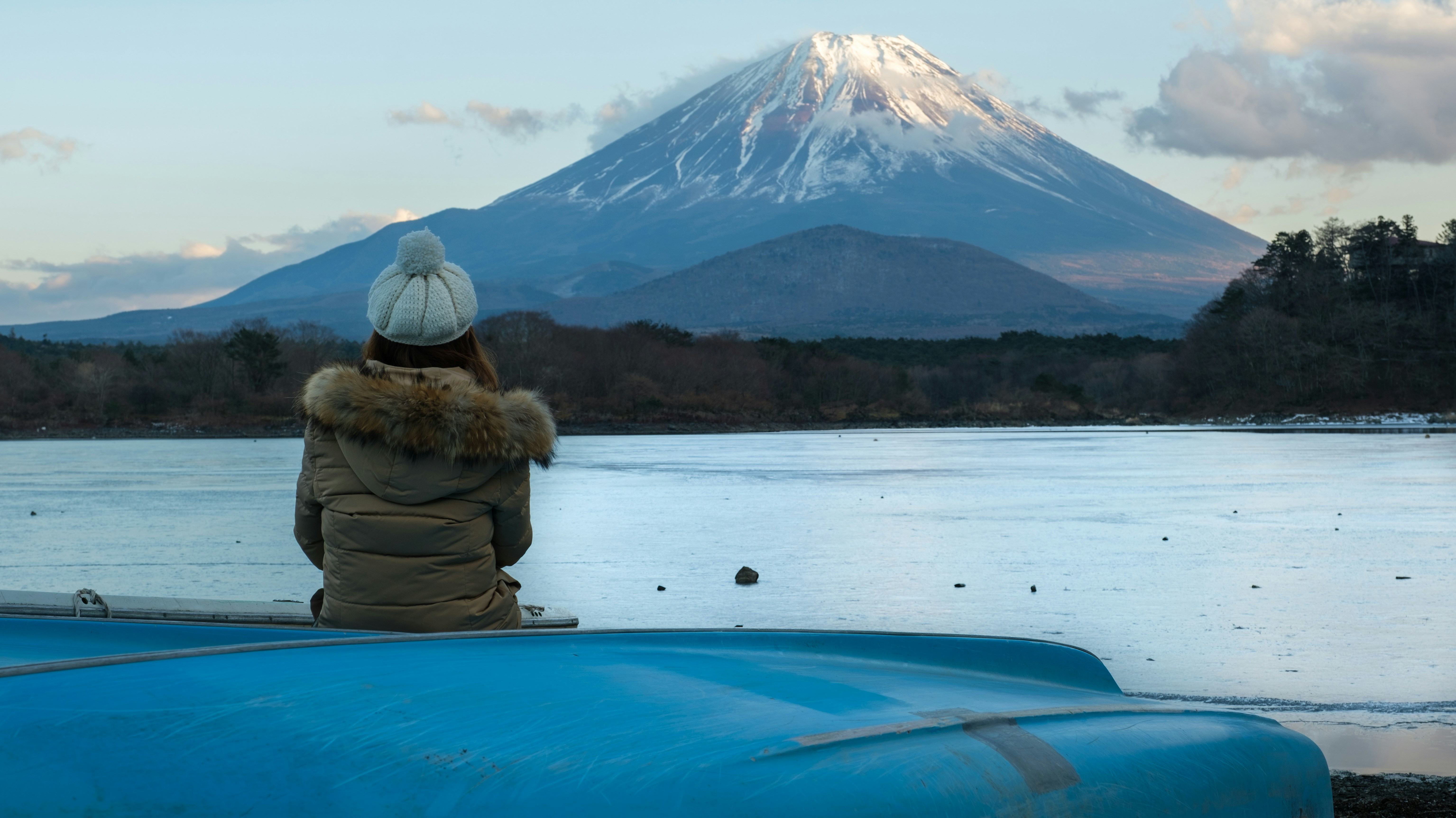 a person sitting on a boat looking at a mountain