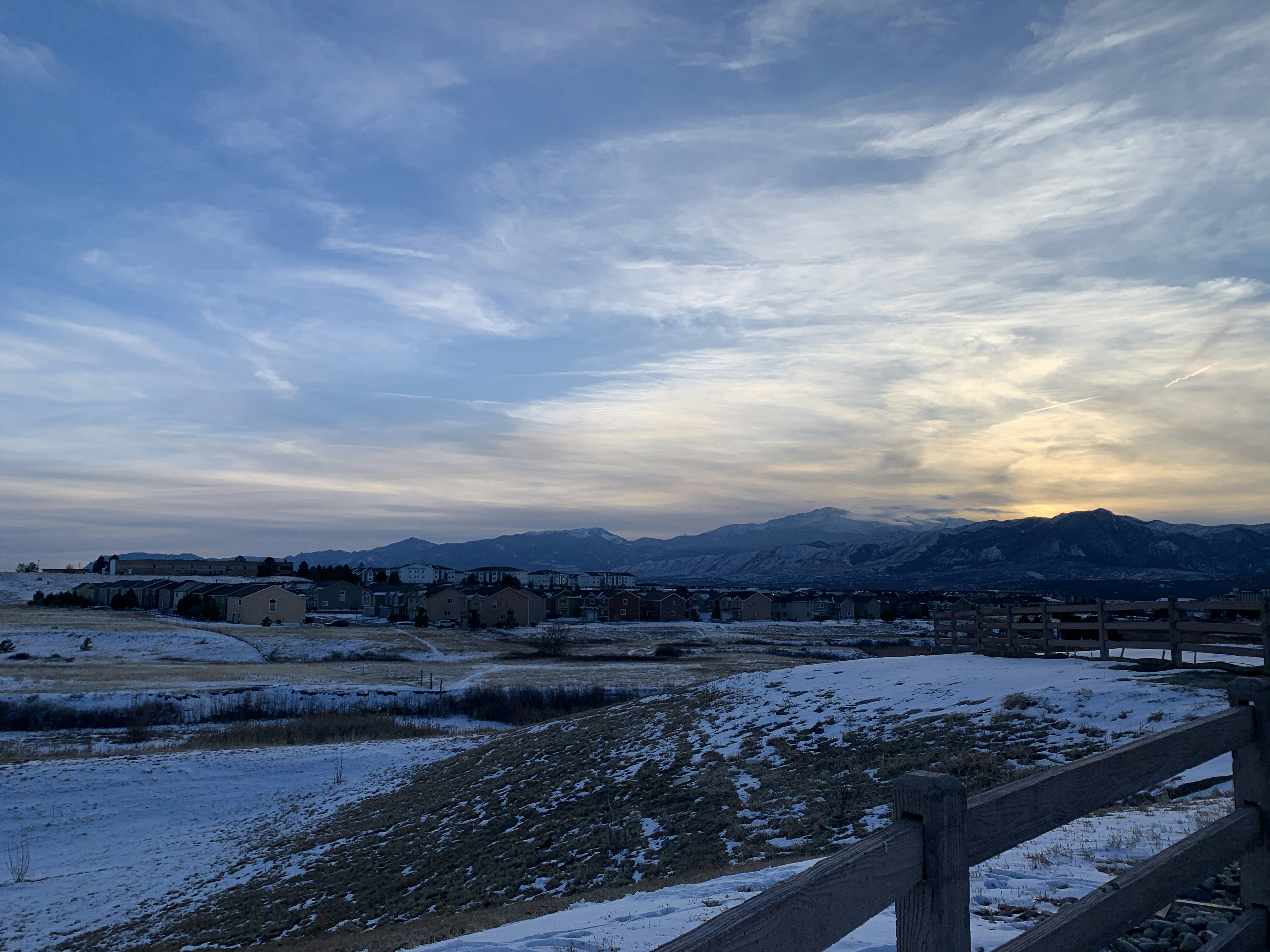 a snow covered field with mountains in the distance