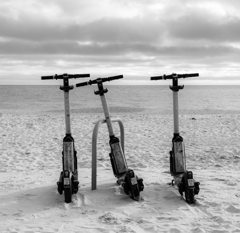 a couple of scooters sitting on top of a sandy beach