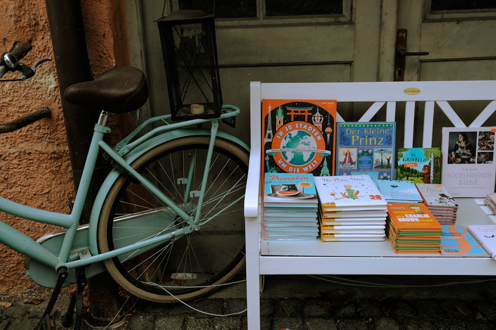 a bicycle parked next to a table with books on it