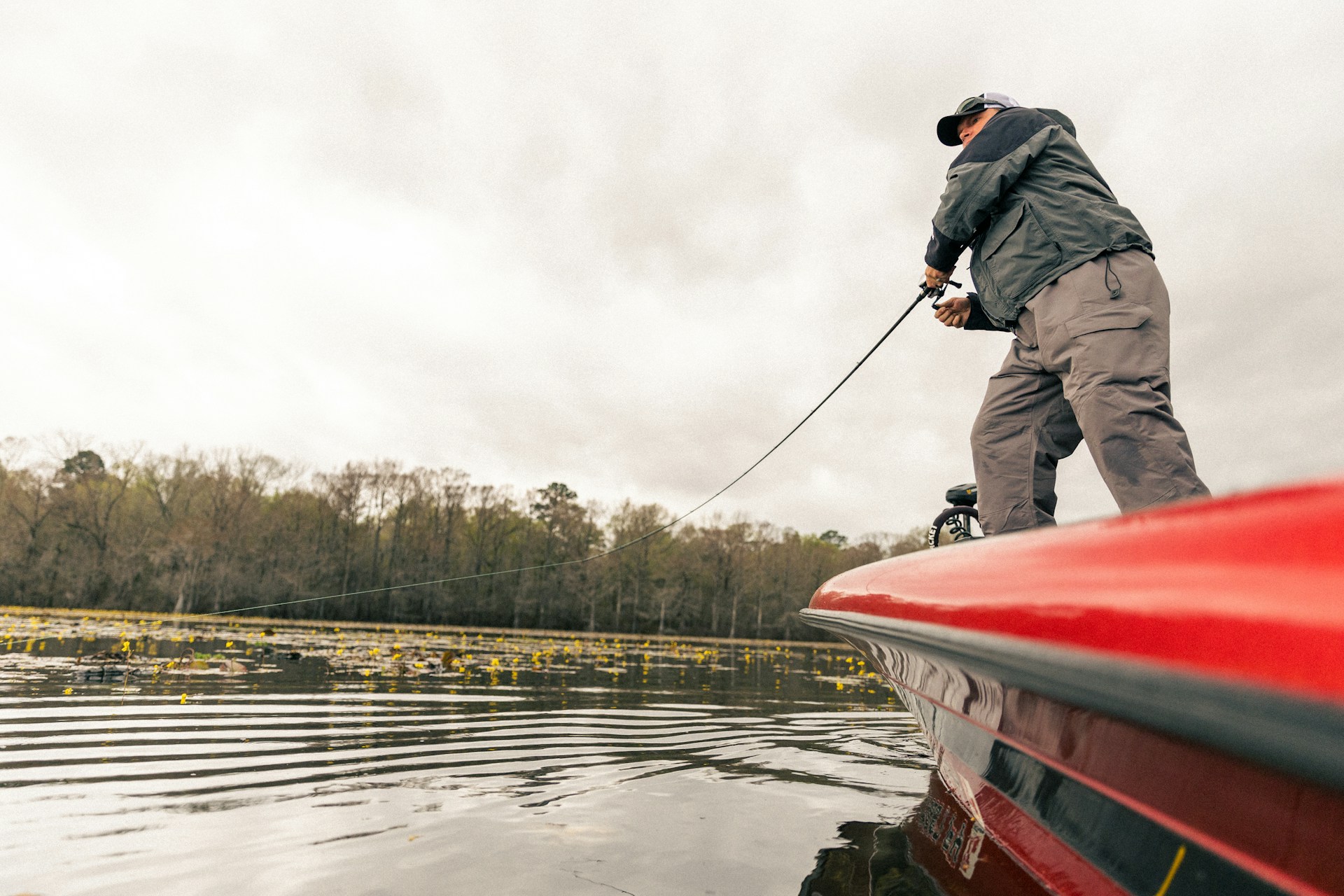 a man on a boat pulling a fishing line