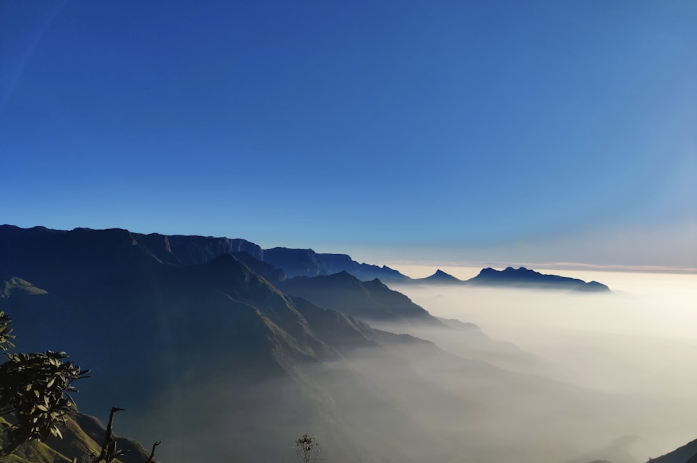 a view of a mountain range with low lying clouds