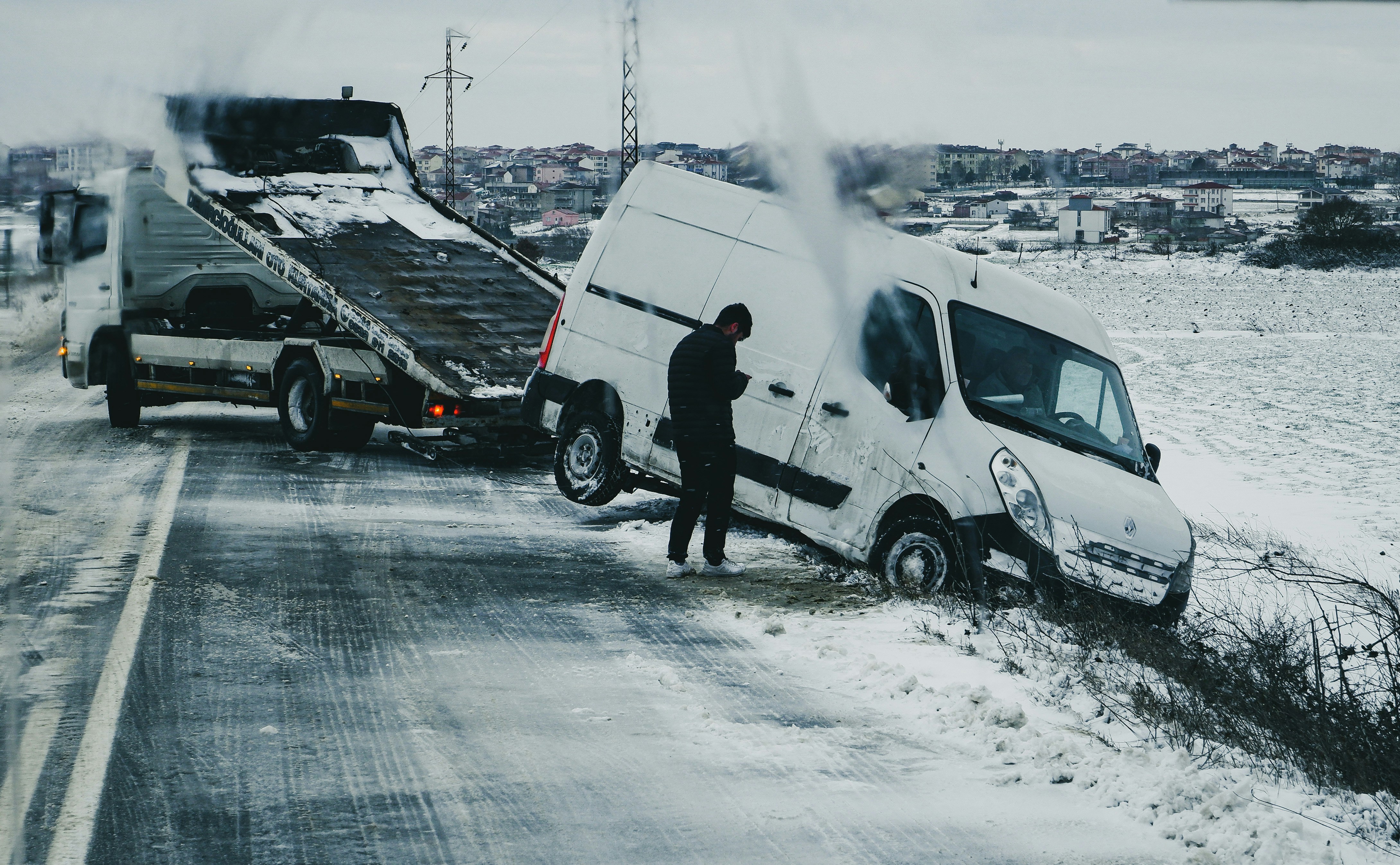 a man standing next to a white van on the side of a road