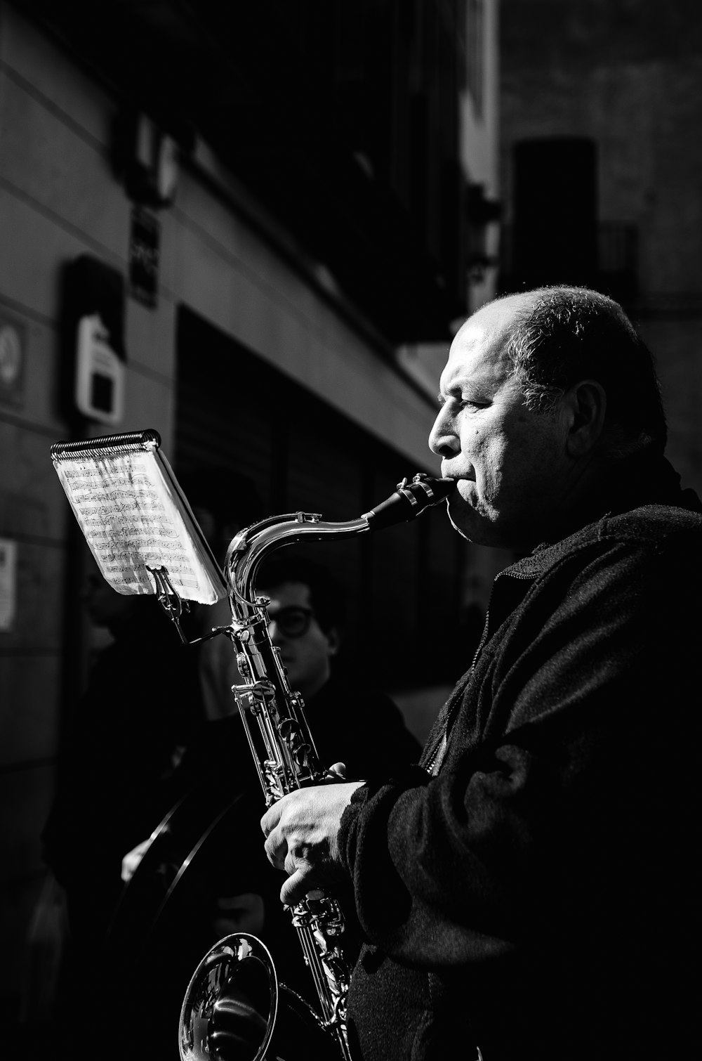a black and white photo of a man playing a saxophone