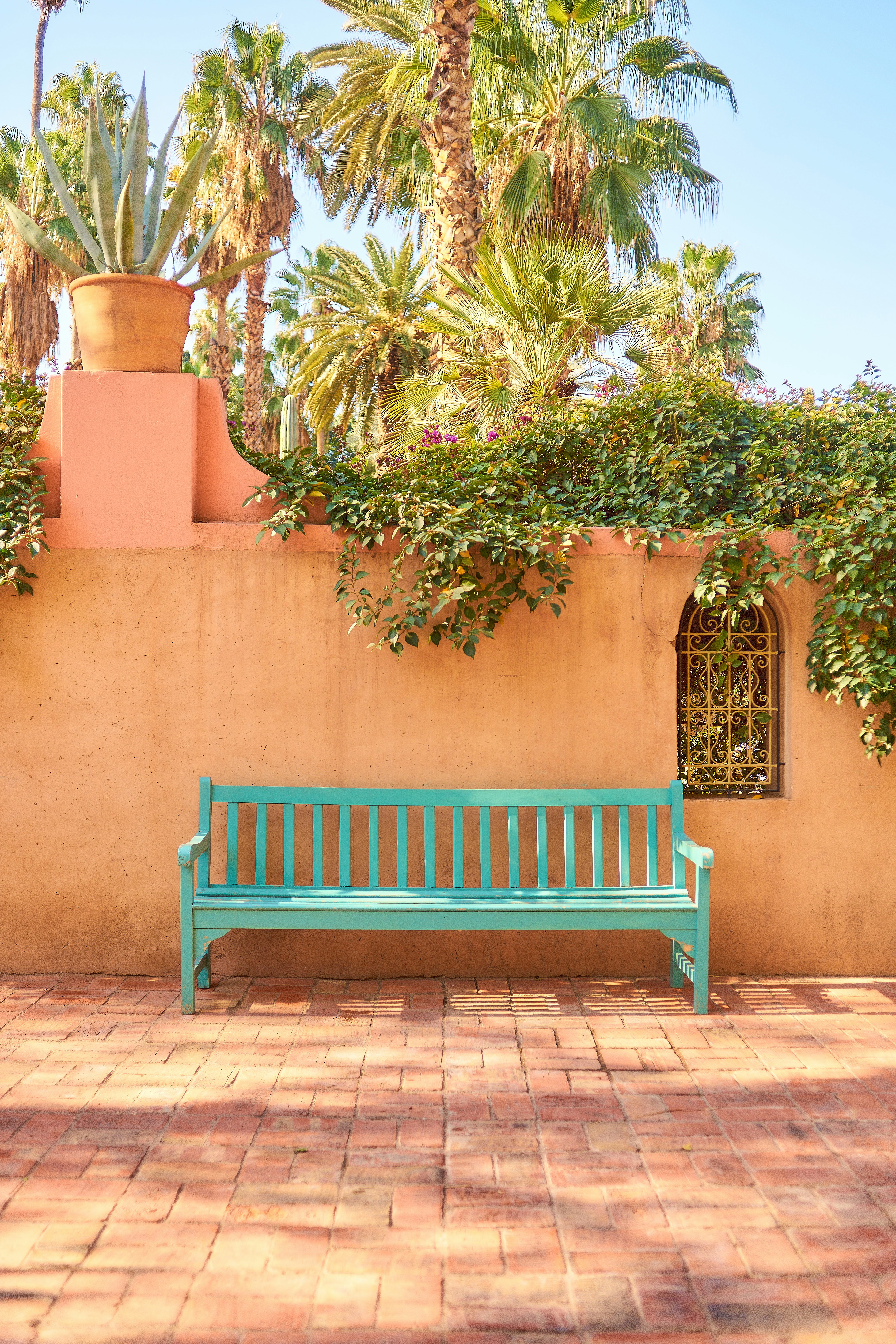 a green bench sitting in front of a building