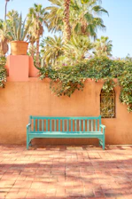 a green bench sitting in front of a building