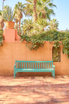 a green bench sitting in front of a building