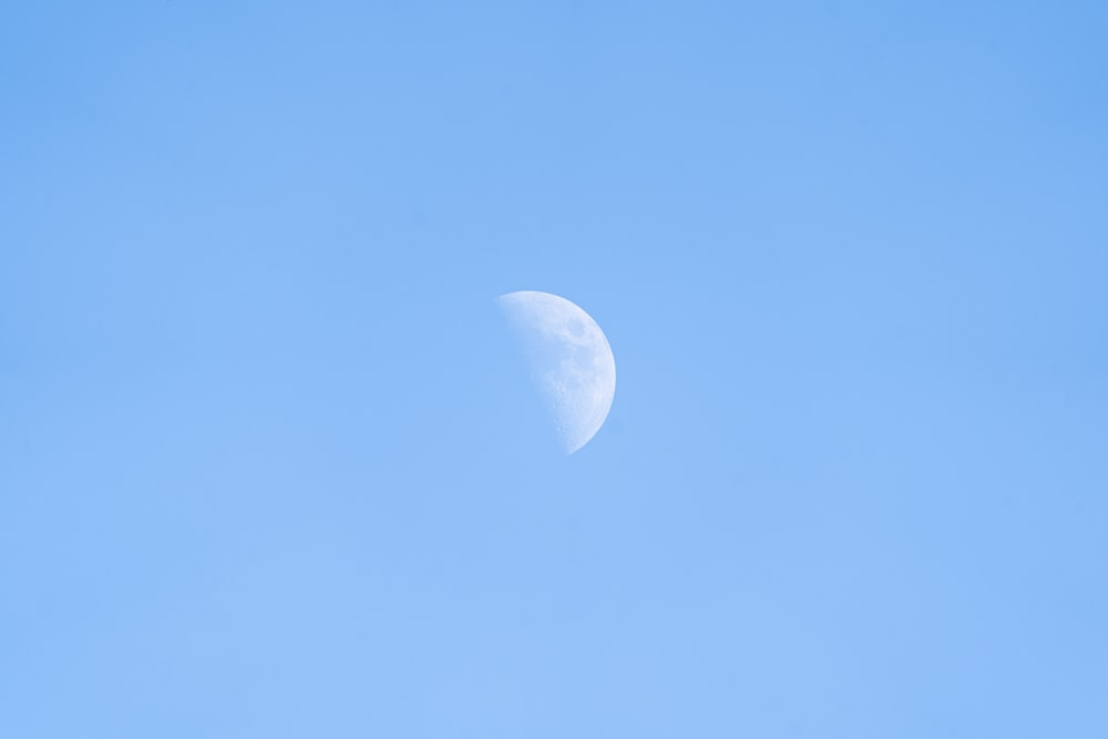 a half moon in a clear blue sky