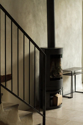 Close-up of a sleek black soapstone radiator with smooth, modern lines in a minimalist room.