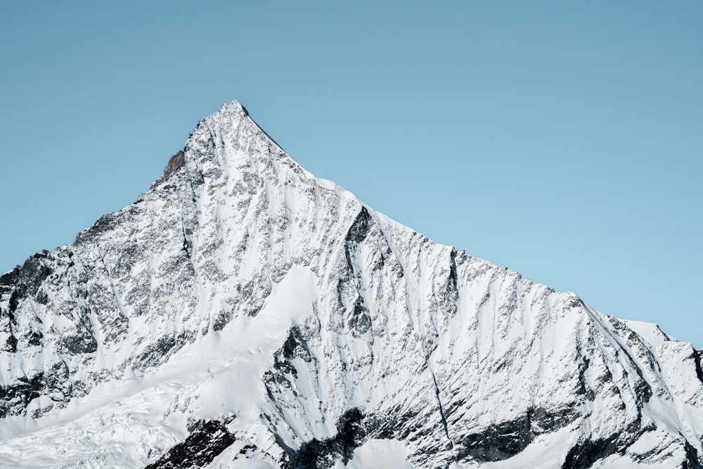 a snow covered mountain with a blue sky in the background