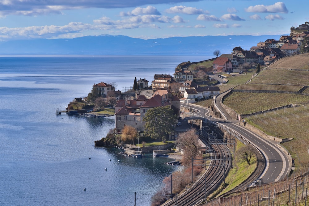 a train traveling down tracks next to a body of water