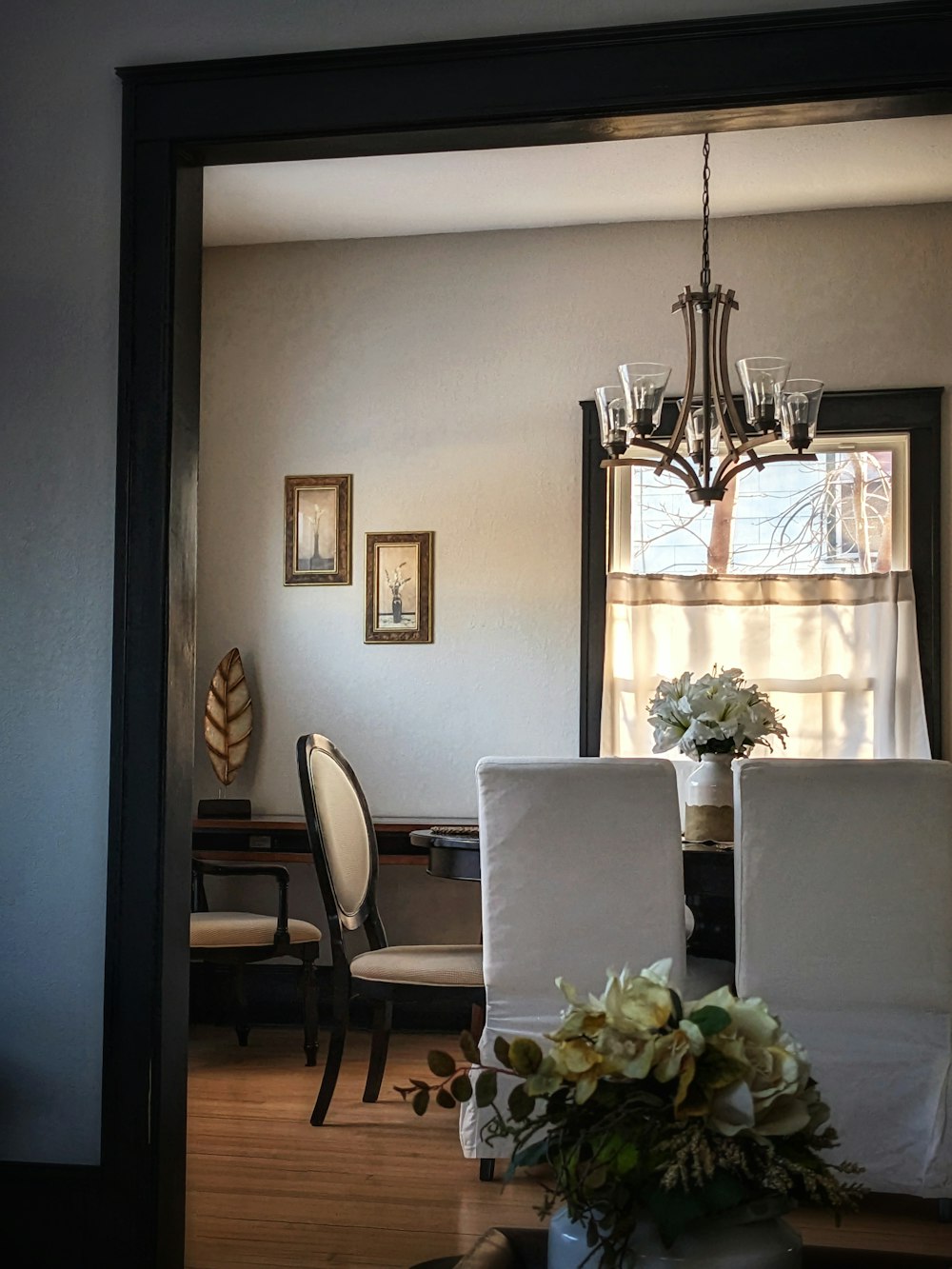 a dining room table with a vase of flowers on it