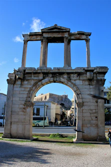 a stone arch with a clock on top of it