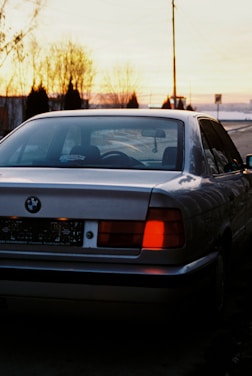 A Silver Raine Transportation vehicle parked by a city street at sunset.
