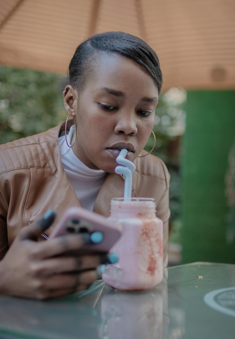 a woman sitting at a table using a cell phone