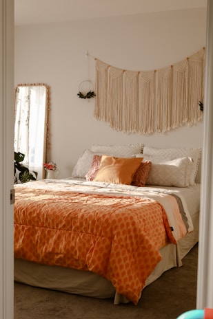 a bedroom with a large bed and orange comforter