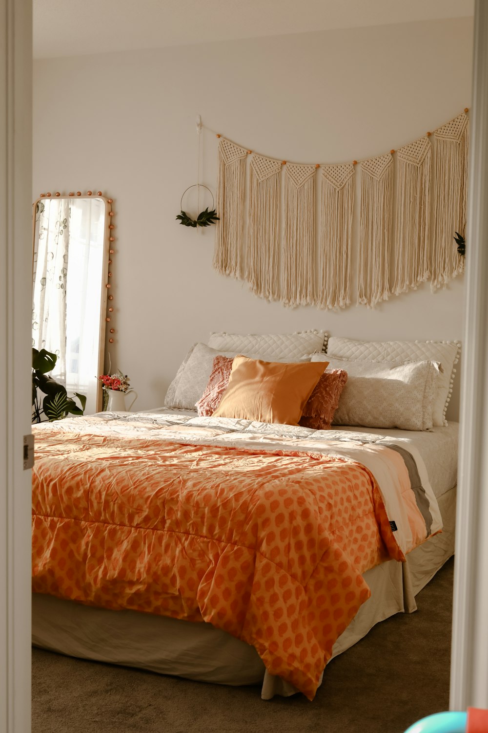 a bedroom with a large bed and orange comforter
