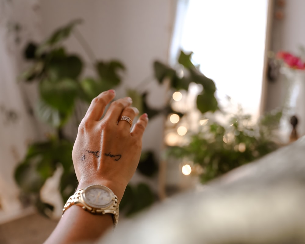a woman's hand with a wrist tattoo