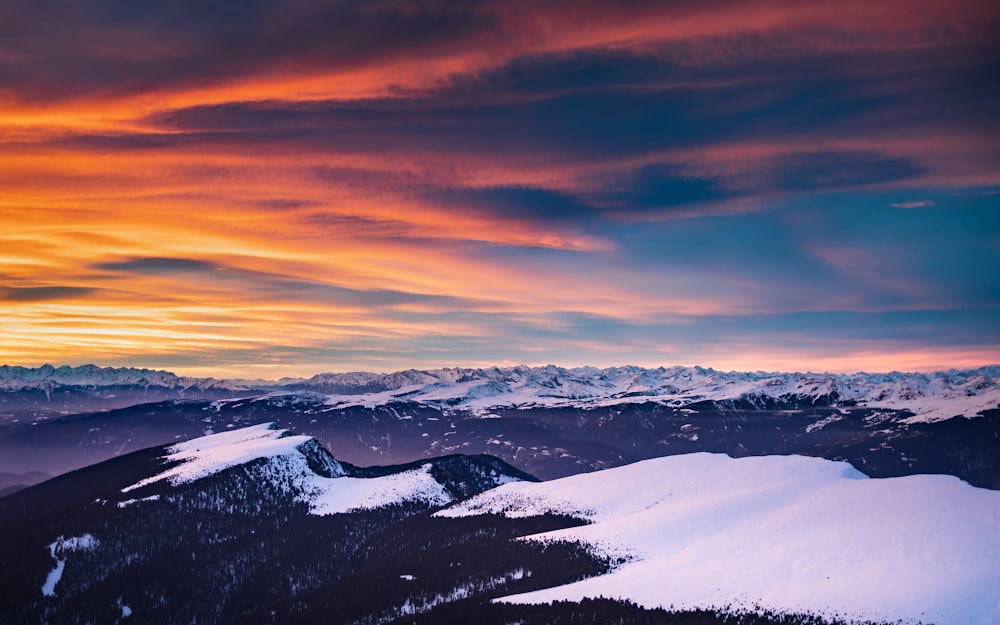 a sunset view of a snowy mountain range