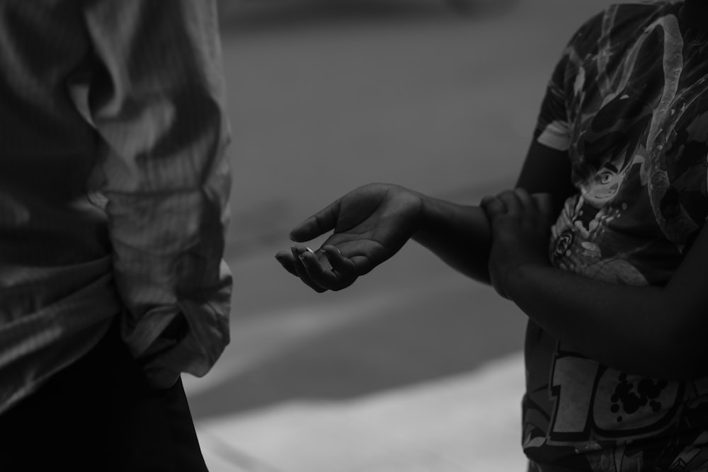 a black and white photo of a person holding a cigarette