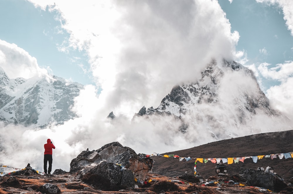 Un uomo in piedi sulla cima di una montagna rocciosa